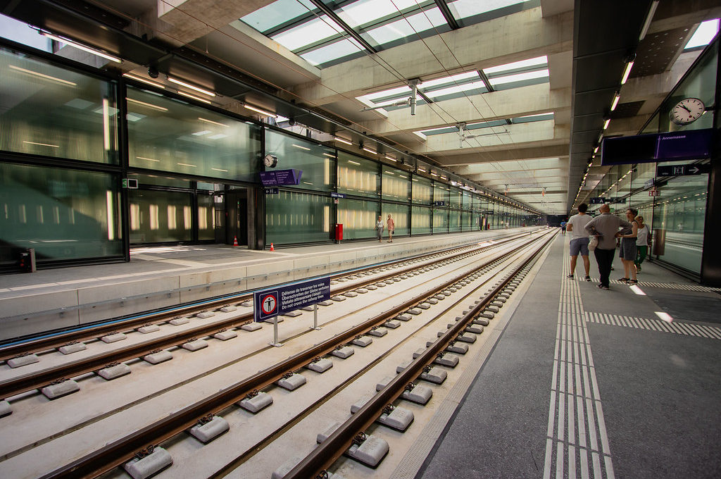 Photo: Vue intérieure d'une gare CEVA. Les voies sont à gauche et le quai, situé sur la droite, est muni de lignes de sécurité et de champs d'éveil.