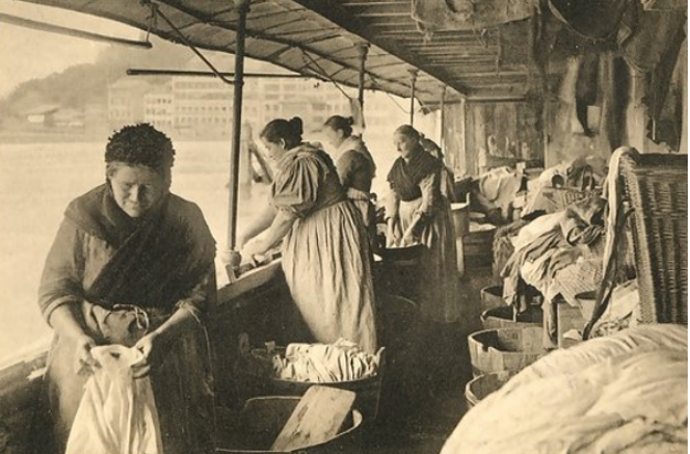 Des blanchisseuses nettoyant le linge au bord du Rhône sur des bateaux-lavoirs.