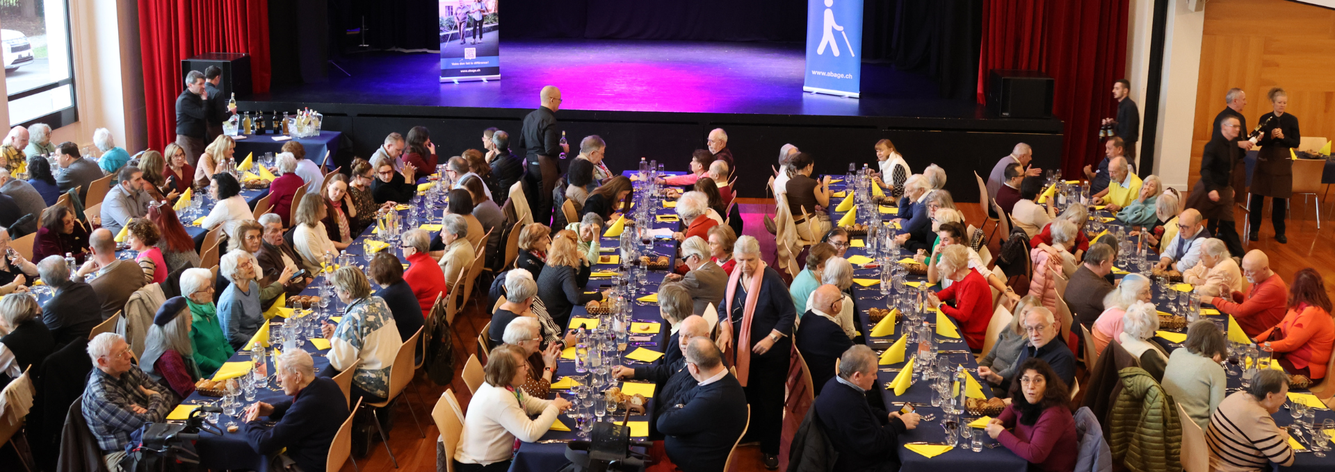 Photo des bénéficiaires de l'ABA lors du repas annuel 2026 dans la salle communale de Chêne-Bougeries