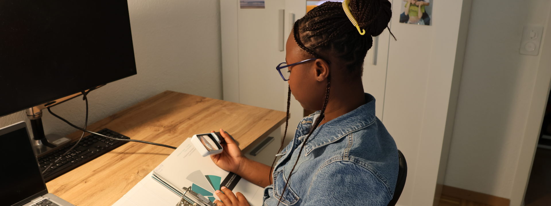 Photo de Rebecca, utilisant une loupe pour lire ses devoirs