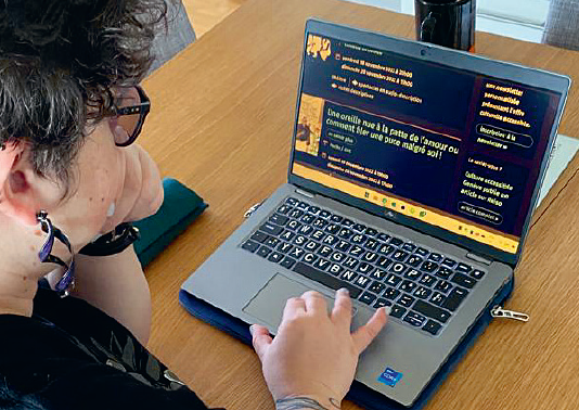 Photo d'Anne, bénéficiaire depuis 2020 à l'ABA, devant un écran d'ordinateur dont l'affichage est adapté à sa vue