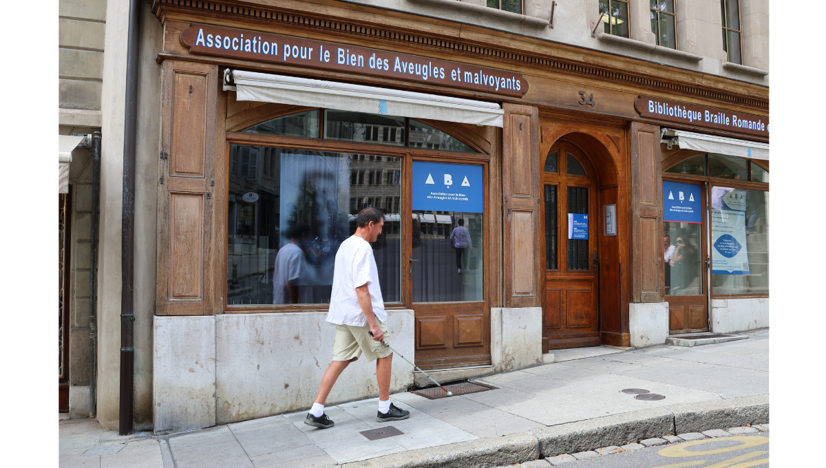 Photographie d'un homme se déplaçant dans la rue avec l'aide d'une canne blanche