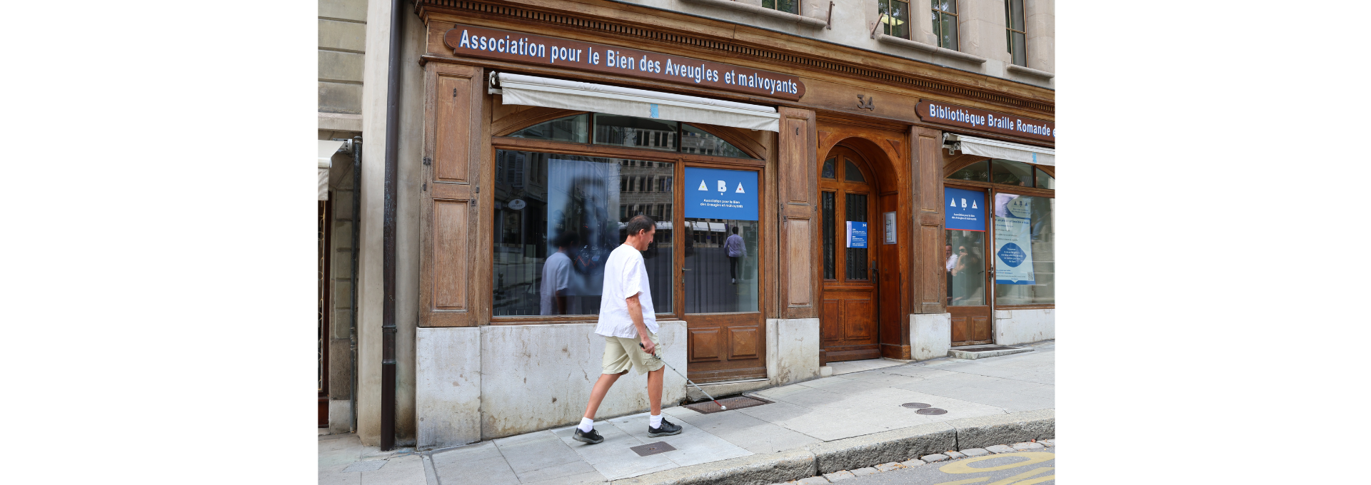 Photographie d'un homme se déplaçant dans la rue avec l'aide d'une canne blanche
